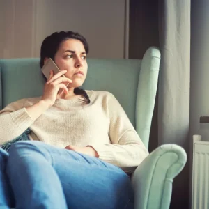 woman on phone looking out window